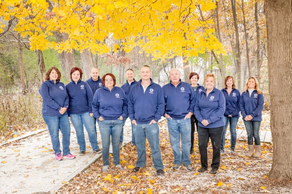 Autumnal picture of Gineris Staff in matching dark blue sweaters.